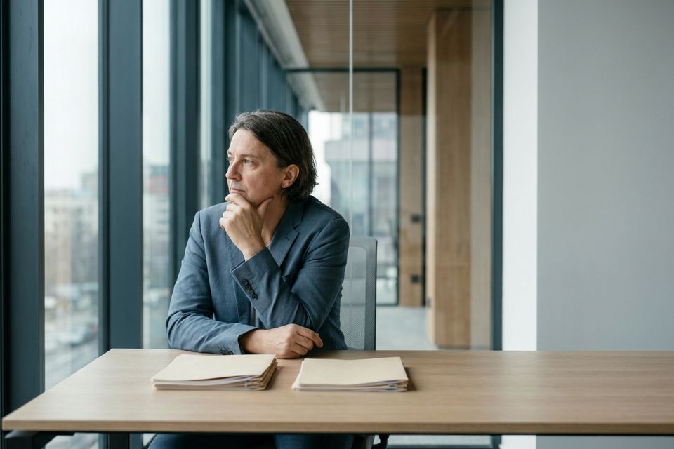 An entrepreneur weighing a decision, documents on the desk